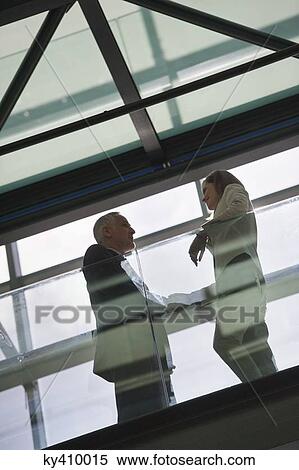 Low angle view of two business executives talking View Large Photo Image Stock Photography - Low angle view of two business executives talking. Fotosearch