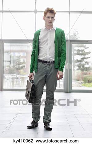 Portrait of a businessman standing in an office lobby View Large Photo Image Stock Image - Portrait of a businessman standing in an office lobby. Fotosearch