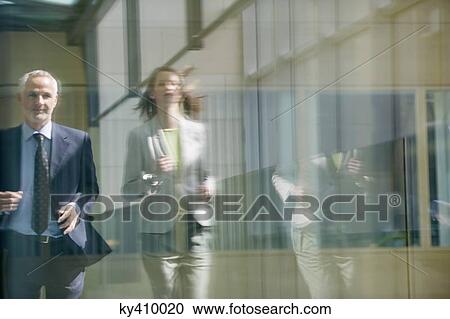 Stock Image - Two business executives running in the corridor. Fotosearch