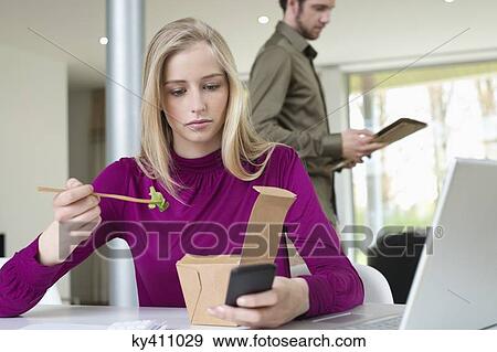 Businesswoman eating salad while working in the home office View Large Photo Image Stock Photo - Businesswoman eating salad while working in the home office. Fotosearch
