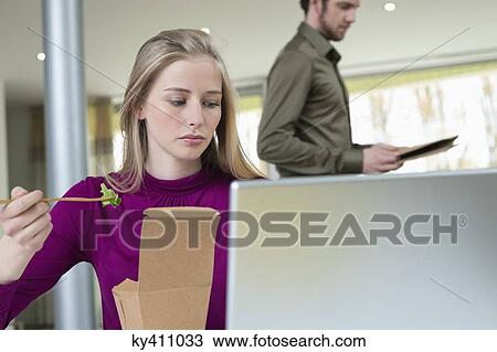 Businesswoman taking salad while working in the home office View Large Photo Image Stock Image - Businesswoman taking salad while working in the home office. Fotosearch