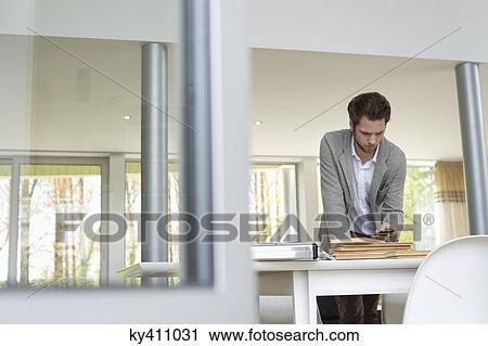 Interior designer using a mobile phone in the office View Large Photo Image Stock Image - Interior designer using a mobile phone in the office. Fotosearch