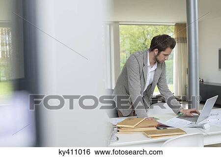 Stock Photograph - Interior designer working on a laptop in the office. Fotosearch