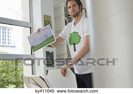 Man holding an ecological poster showing wind turbine View Large Photo Image Stock Photography - Man holding an ecological poster showing wind turbine. Fotosearch