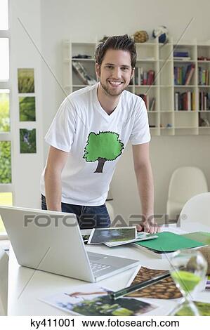 Stock Image - Man working on environment awareness posters. Fotosearch