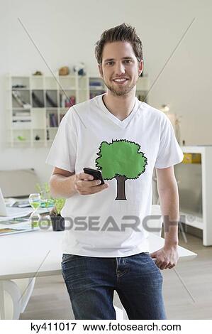 Portrait of a man holding a mobile phone View Large Photo Image Stock Photo - Portrait of a man holding a mobile phone. Fotosearch