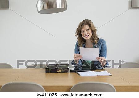 Stock Photography - Portrait of a woman sorting out bills. Fotosearch