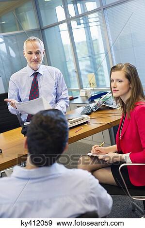 Business executives discussing in an office View Large Photo Image Stock Photo - Business executives discussing in an office. Fotosearch