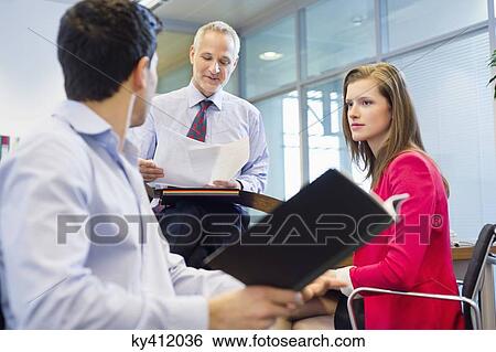 Stock Photograph - Business executives discussing in an office. Fotosearch