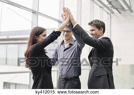 Stock Photography - Business executives giving high-five to each other. Fotosearch