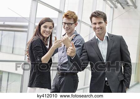 Business executives showing thumbs up and smiling in an office View Large Photo Image Stock Image - Business executives showing thumbs up and smiling in an office. Fotosearch