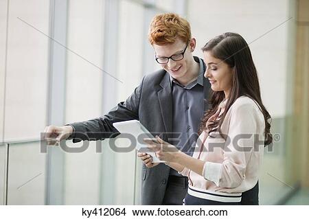 Business executives using a digital tablet in an office View Large Photo Image Picture - Business executives using a digital tablet in an office. Fotosearch