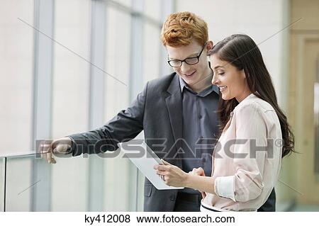 Stock Photo - Business executives using a digital tablet in an office. Fotosearch
