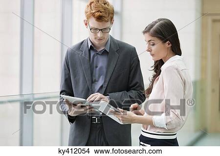 Business executives using digital tablets in an office View Large Photo Image Picture - Business executives using digital tablets in an office. Fotosearch
