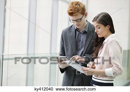Business executives using digital tablets in an office View Large Photo Image Stock Image - Business executives using digital tablets in an office. Fotosearch