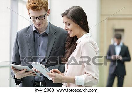 Business executives using digital tablets in an office View Large Photo Image Stock Photo - Business executives using digital tablets in an office. Fotosearch