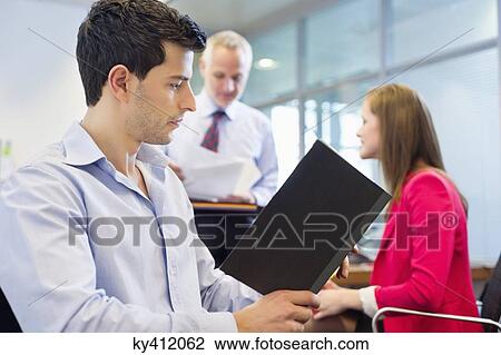 Stock Image - Business executives working in an office. Fotosearch