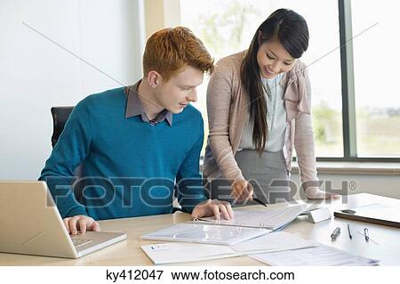 Businessman examining documents with his secretary View Large Photo Image Stock Photo - Businessman examining documents with his secretary. Fotosearch