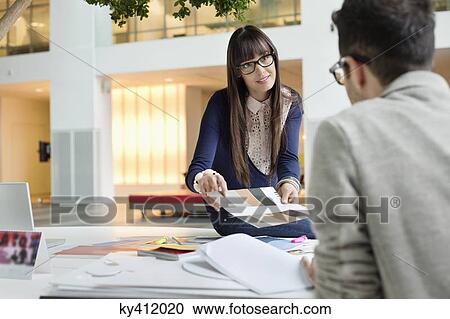 Stock Image - Fashion designers discussing in an office. Fotosearch
