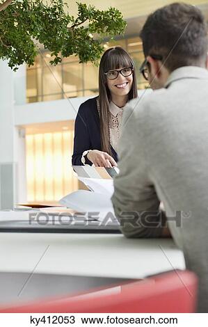 Stock Image - Fashion designers discussing in an office. Fotosearch
