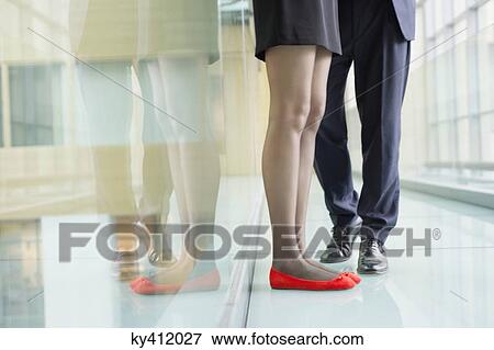 Low section view of business executives standing in an office corridor View Large Photo Image Stock Photo - Low section view of business executives standing in an office corridor. Fotosearch