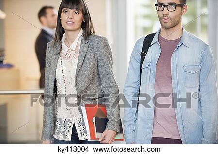 Picture - Business executives entering in an office lobby. Fotosearch