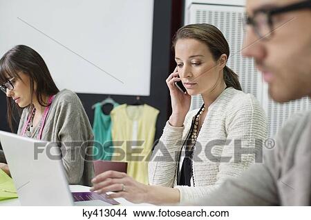 Picture - Fashion designers working in an office. Fotosearch