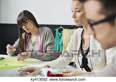 Stock Image - Fashion designers working in an office. Fotosearch