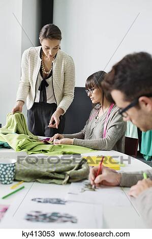 Stock Image - Fashion designers working in an office. Fotosearch