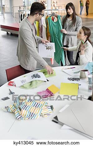 Stock Photography - Fashion designers working in an office. Fotosearch