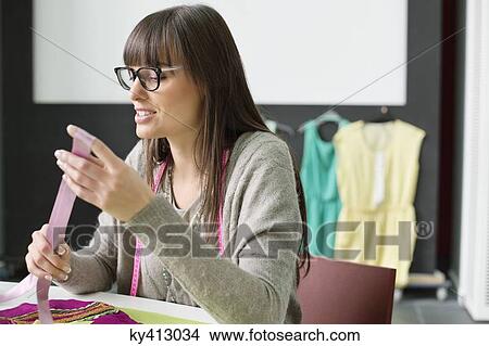 Picture - Female fashion designer working in an office. Fotosearch