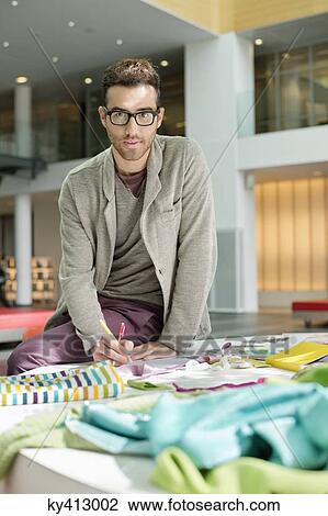 Male fashion designer working in an office View Large Photo Image Stock Image - Male fashion designer working in an office. Fotosearch