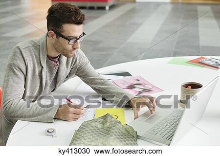 Male fashion designer working in an office View Large Photo Image Stock Image - Male fashion designer working in an office. Fotosearch