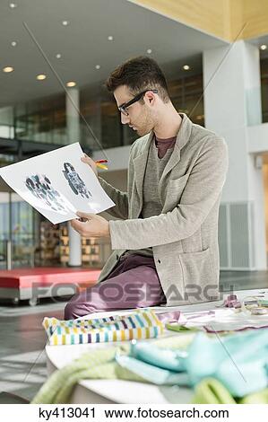 Male fashion designer working in an office View Large Photo Image Stock Image - Male fashion designer working in an office. Fotosearch