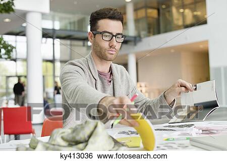 Stock Photograph - Male fashion designer working in an office. Fotosearch