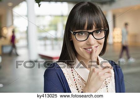 Stock Photography - Portrait of a businesswoman with finger on lips. Fotosearch