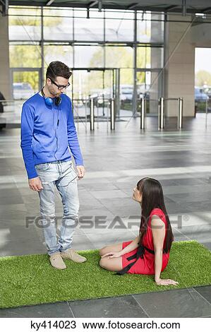 Business executives relaxing on grass mat in an office lobby View Large Photo Image Stock Image - Business executives relaxing on grass mat in an office lobby. Fotosearch