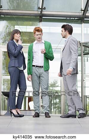 Stock Photography - Business executives smoking in front of an office building. Fotosearch