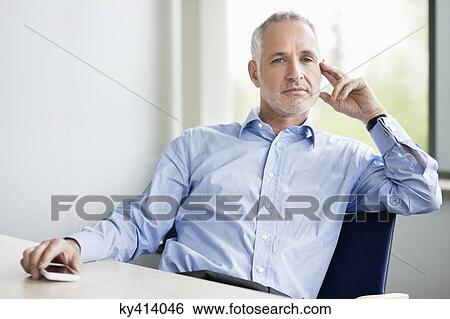 Stock Photograph - Businessman sitting in an office. Fotosearch