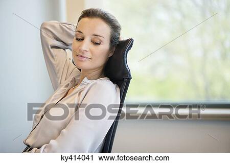 Businesswoman day dreaming in an office View Large Photo Image Stock Image - Businesswoman day dreaming in an office. Fotosearch
