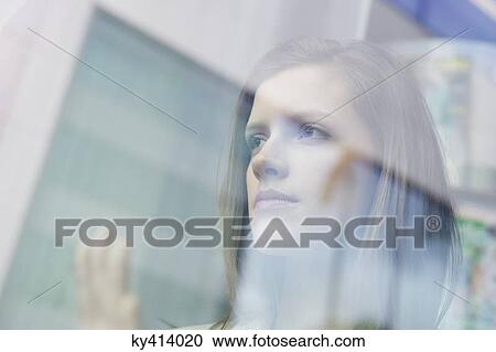 Businesswoman looking through the glass of a window View Large Photo Image Stock Image - Businesswoman looking through the glass of a window. Fotosearch