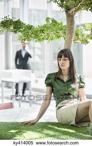 Businesswoman relaxing on grass mat View Large Photo Image Stock Photography - Businesswoman relaxing on grass mat. Fotosearch