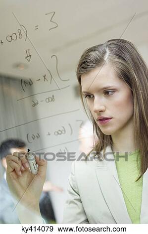 Businesswoman writing numeric figures on a glass surface View Large Photo Image Stock Photo - Businesswoman writing numeric figures on a glass surface. Fotosearch