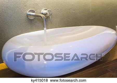 Stock Photo - Bathroom sink with running water. Fotosearch