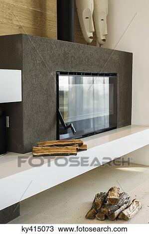 Stock Image - Firewood near fireplace insert. Fotosearch