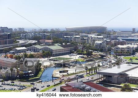 Elevated view of buildings in a city with Green Point Soccer Stadium in the background, Cape Town, South Africa View Large Photo Image Picture - Elevated view of buildings in a city with Green Point Soccer Stadium in the background, Cape Town, South Africa. Fotosearch