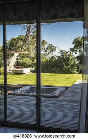 Lawn and a hot tub viewed from a glass door of a house View Large Photo Image Stock Photograph - Lawn and a hot tub viewed from a glass door of a house. Fotosearch