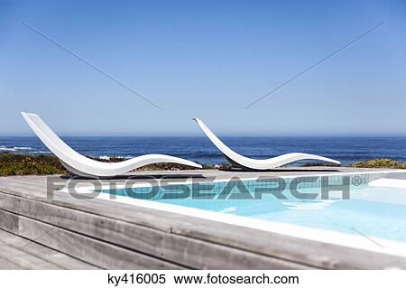 Modern reclining chairs at the poolside View Large Photo Image Stock Photography - Modern reclining chairs at the poolside. Fotosearch
