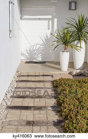 Stock Image - Path leading towards the entrance of a house. Fotosearch