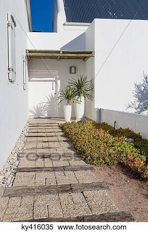 Path leading towards the entrance of a house View Large Photo Image Stock Photography - Path leading towards the entrance of a house. Fotosearch